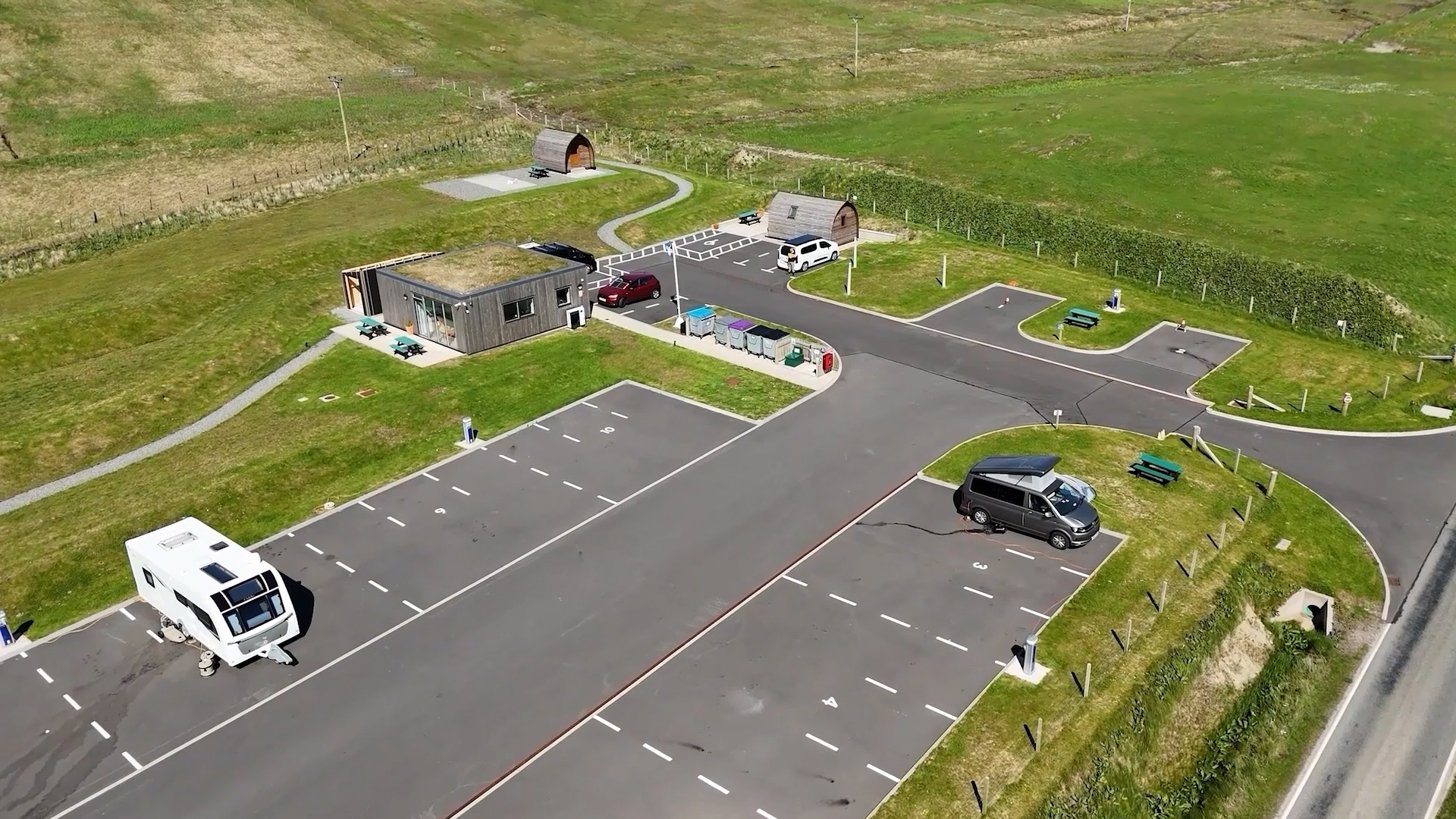 Aerial drone view of a campsite with glamping pods and motorhome pitches