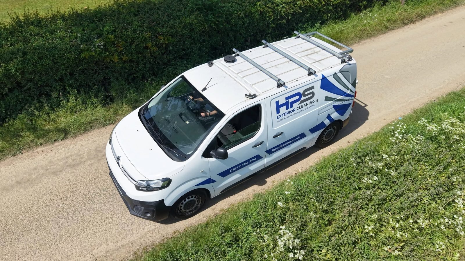 Overhead drone shot of HPS Exterior Cleaning van driving on rural road